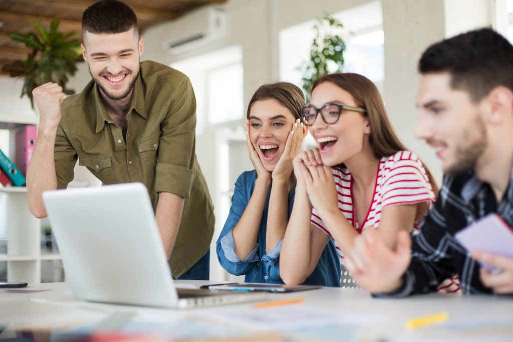 young joyful business people happily working laptop together group smiling men women spending time modern cozy office